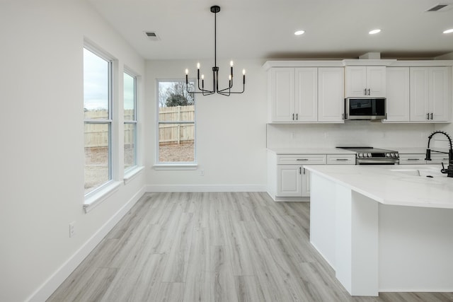 kitchen featuring appliances with stainless steel finishes, light countertops, visible vents, and a sink