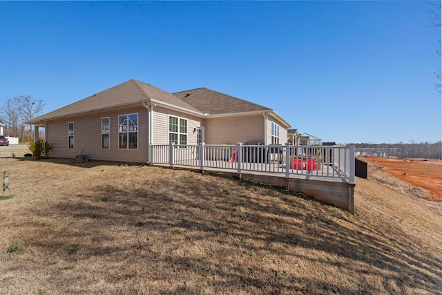 rear view of house with a deck and a yard