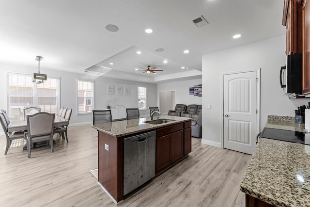 kitchen with visible vents, a raised ceiling, light wood-type flooring, stainless steel dishwasher, and a sink