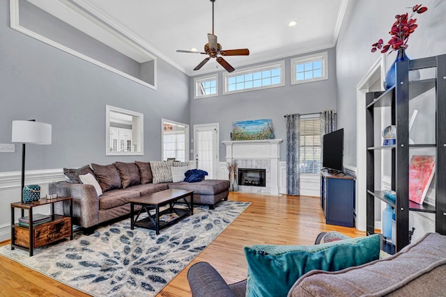 living room with ornamental molding, light wood-type flooring, and a wealth of natural light