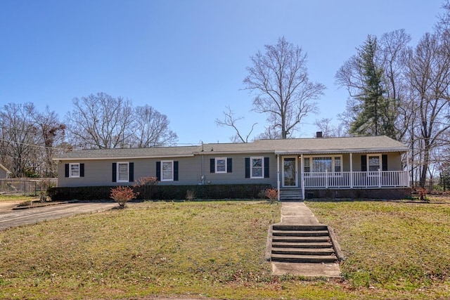 ranch-style house featuring covered porch and a front lawn