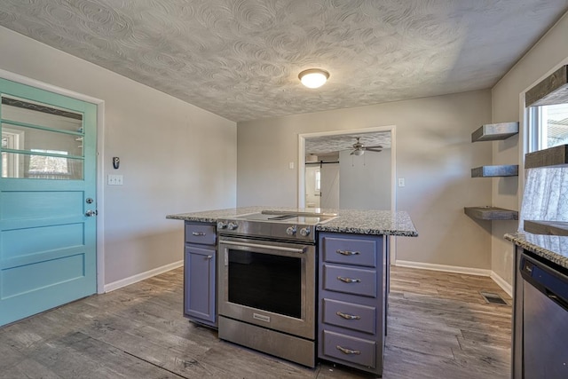 kitchen with baseboards, dark wood finished floors, stainless steel appliances, blue cabinetry, and open shelves