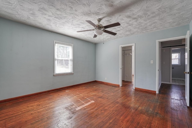 spare room featuring hardwood / wood-style flooring, a textured ceiling, baseboards, and a ceiling fan