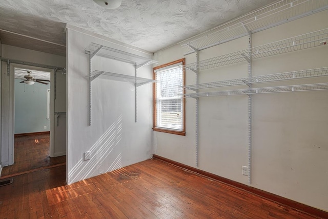 spacious closet featuring a ceiling fan, wood-type flooring, and visible vents