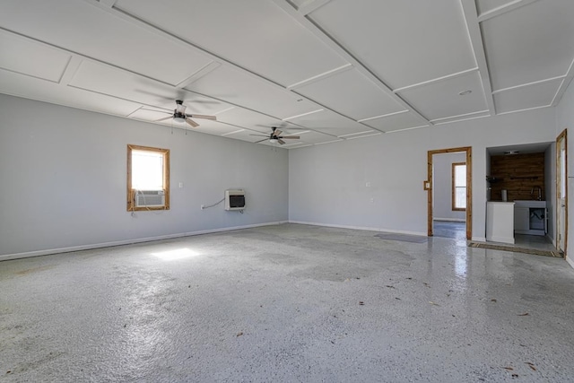 spare room featuring heating unit, a ceiling fan, cooling unit, baseboards, and speckled floor