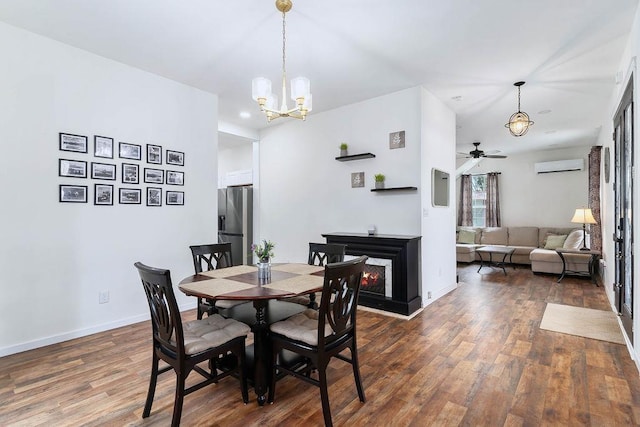 dining space featuring a lit fireplace, an AC wall unit, wood finished floors, and baseboards