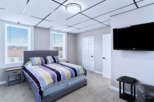 bedroom with carpet floors, a drop ceiling, and baseboards