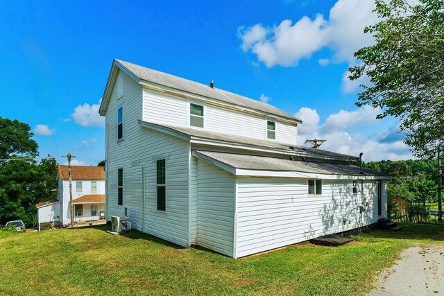 rear view of property featuring a yard and central AC