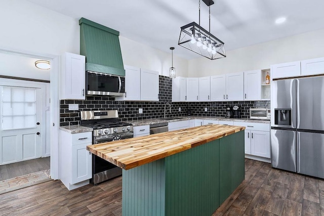 kitchen featuring butcher block countertops, appliances with stainless steel finishes, dark wood-type flooring, open shelves, and a sink