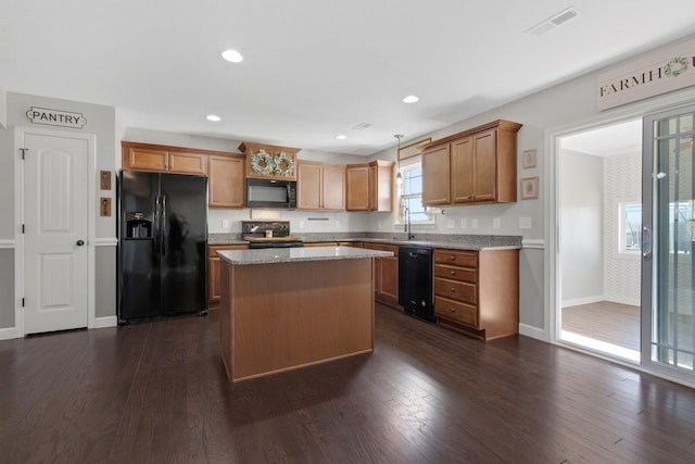 kitchen with black appliances, visible vents, dark wood finished floors, and a center island