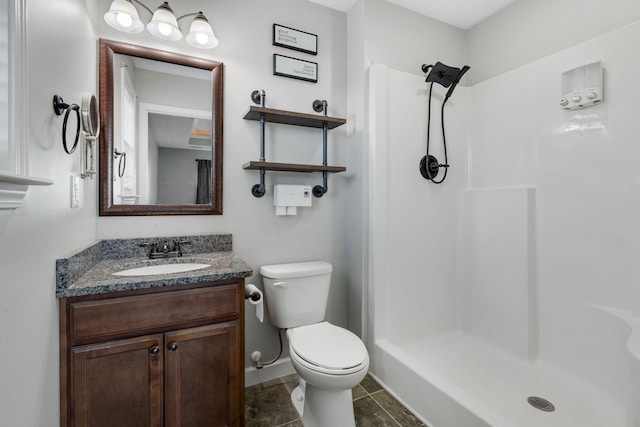 bathroom with toilet, a stall shower, and vanity