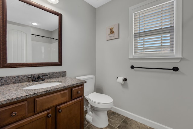 bathroom with toilet, tile patterned floors, vanity, and baseboards