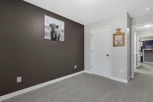 unfurnished bedroom featuring carpet floors and baseboards