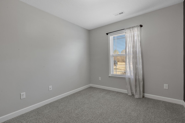 carpeted empty room with visible vents and baseboards