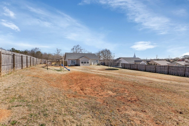 view of yard with a fenced backyard and a playground