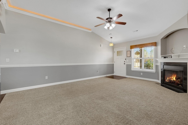 unfurnished living room featuring a fireplace with flush hearth, visible vents, baseboards, vaulted ceiling, and carpet