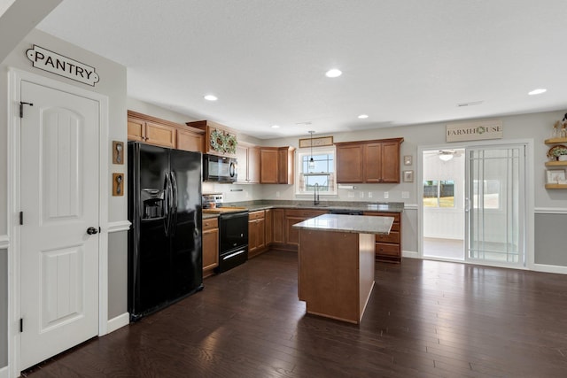 kitchen featuring a center island, brown cabinets, recessed lighting, dark wood-type flooring, and black appliances