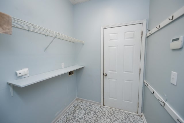 clothes washing area featuring baseboards