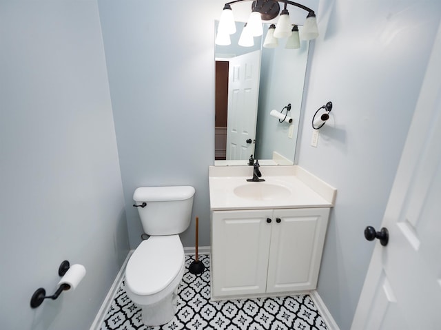 half bath with baseboards, toilet, and vanity