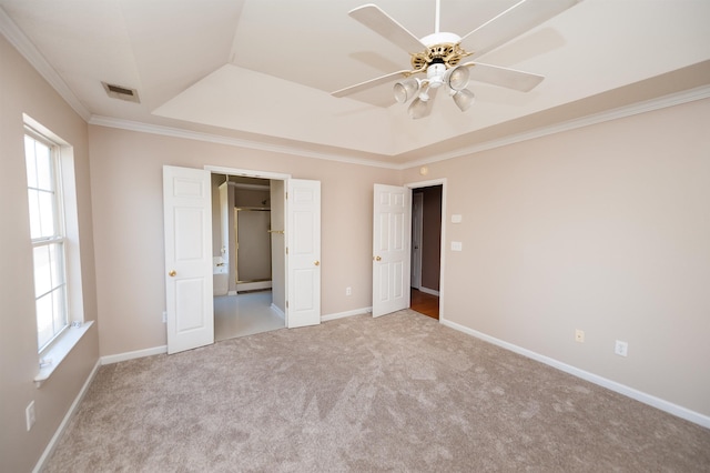 unfurnished bedroom featuring multiple windows, visible vents, ornamental molding, and carpet flooring