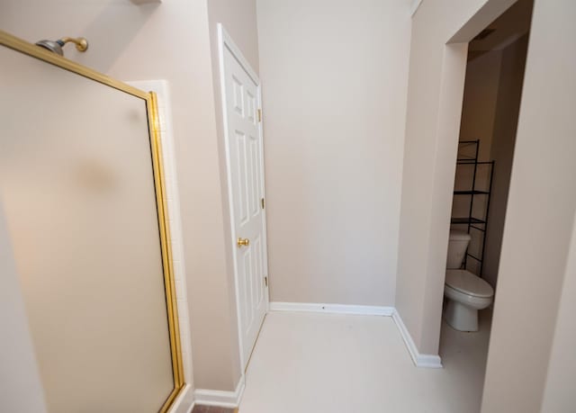 full bathroom featuring a stall shower, baseboards, and toilet