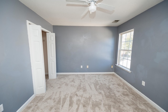 unfurnished bedroom featuring baseboards, visible vents, ceiling fan, and carpet