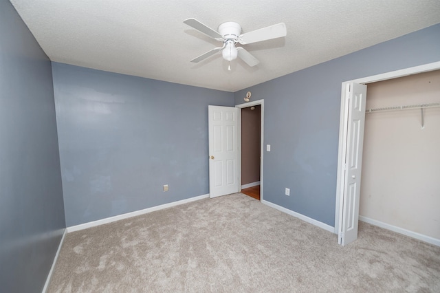 unfurnished bedroom with a closet, carpet flooring, a textured ceiling, and baseboards