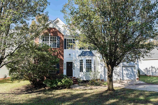view of front of property featuring a front lawn, driveway, a garage, and brick siding