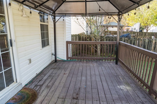 wooden terrace featuring a gazebo and fence