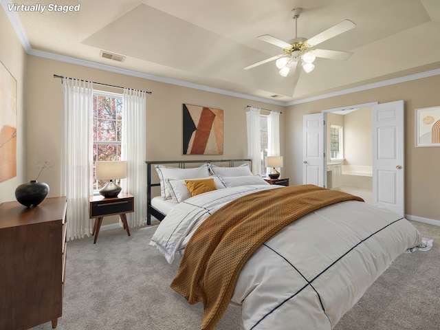 bedroom featuring light colored carpet, ornamental molding, baseboards, a raised ceiling, and visible vents