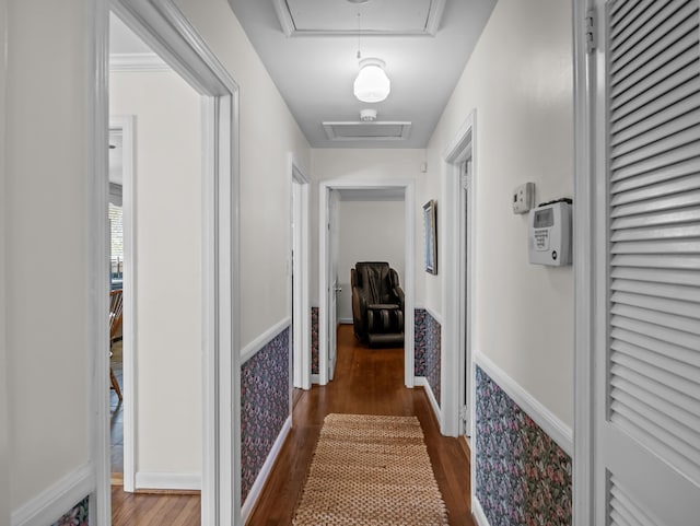 corridor featuring attic access and wood finished floors