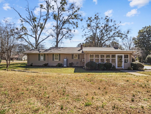 single story home with a front yard and a sunroom