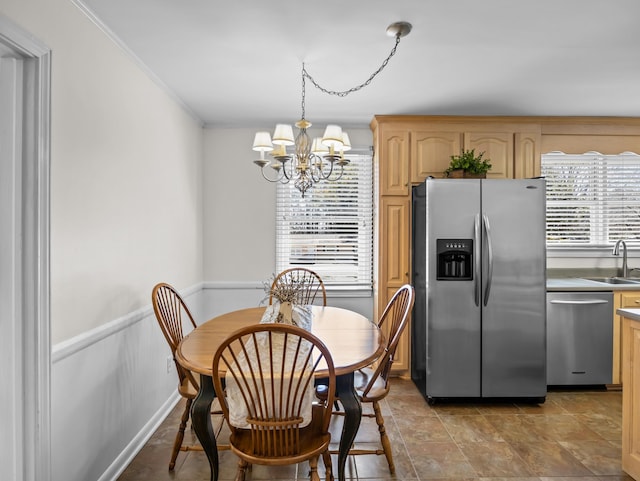 dining space featuring a wainscoted wall, a chandelier, and crown molding