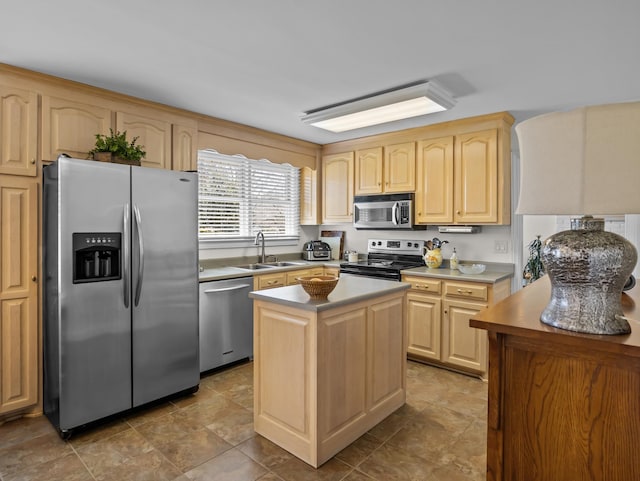 kitchen featuring light countertops, light brown cabinetry, appliances with stainless steel finishes, a kitchen island, and a sink