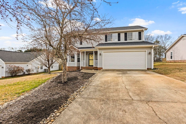 traditional-style house with a garage, a front yard, and concrete driveway