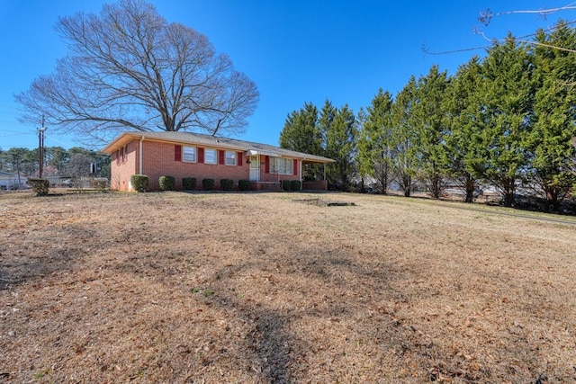 ranch-style house featuring brick siding and a front lawn