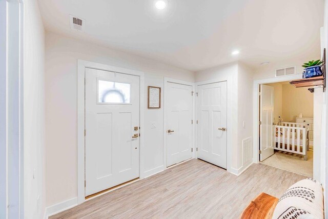 entryway with light wood finished floors, recessed lighting, visible vents, and baseboards