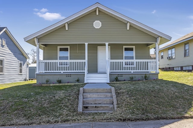 bungalow featuring covered porch and a front lawn