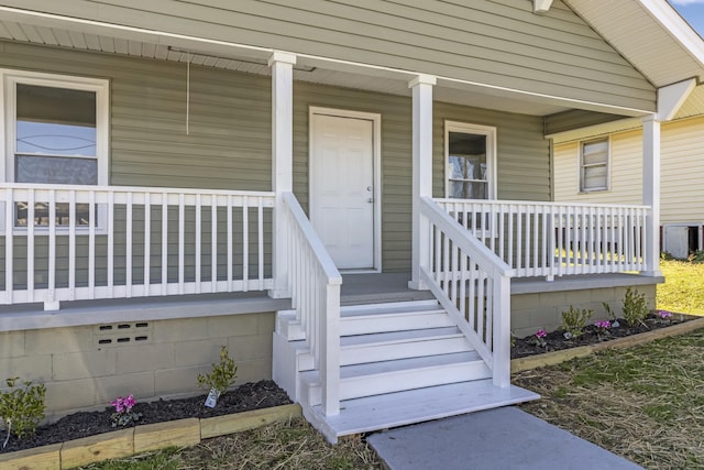 property entrance with a porch, cooling unit, and crawl space