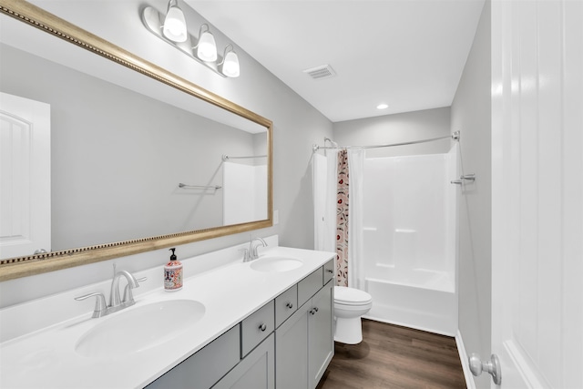 full bathroom featuring toilet, shower / bath combination with curtain, a sink, and wood finished floors