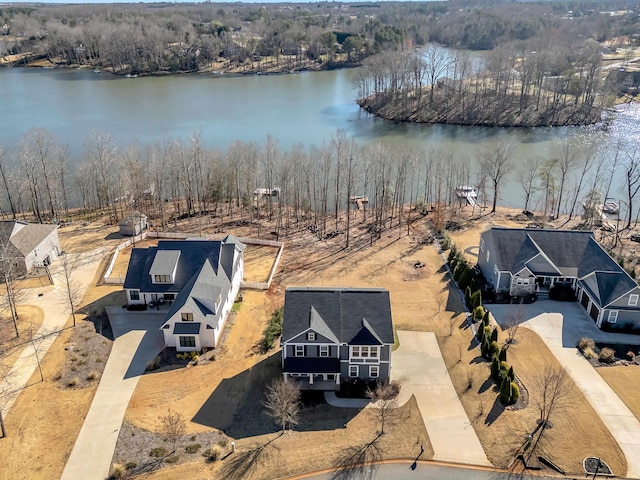 aerial view with a water view and a wooded view