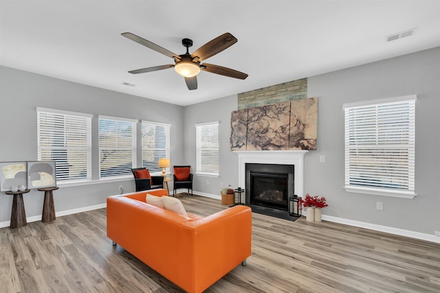 living room featuring light wood-type flooring, baseboards, and visible vents