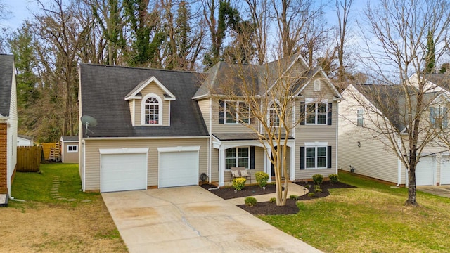 view of front of house featuring a garage, driveway, a front lawn, and fence