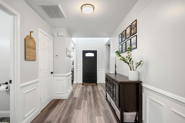 entryway featuring wainscoting, visible vents, and wood finished floors