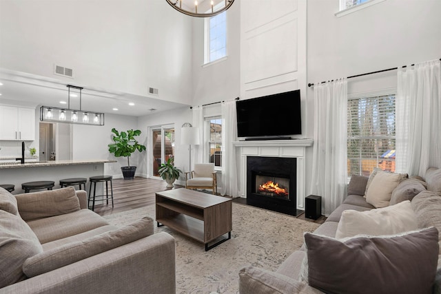 living area featuring a wealth of natural light, light wood finished floors, and visible vents