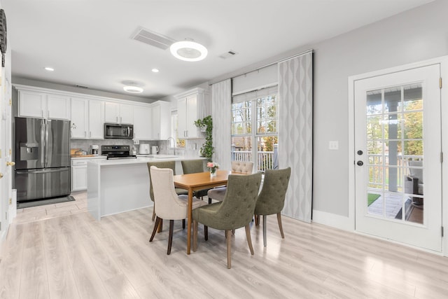 dining room featuring light wood-style floors, baseboards, visible vents, and recessed lighting