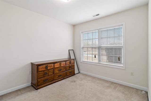 carpeted spare room with visible vents and baseboards