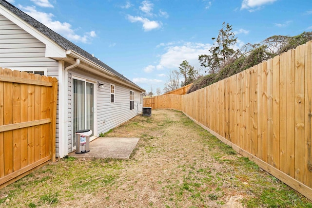 view of yard featuring a fenced backyard and central AC