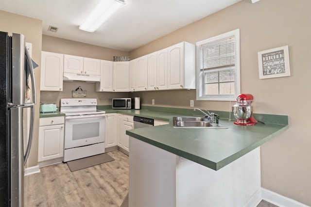 kitchen featuring under cabinet range hood, stainless steel appliances, a peninsula, a sink, and white cabinetry