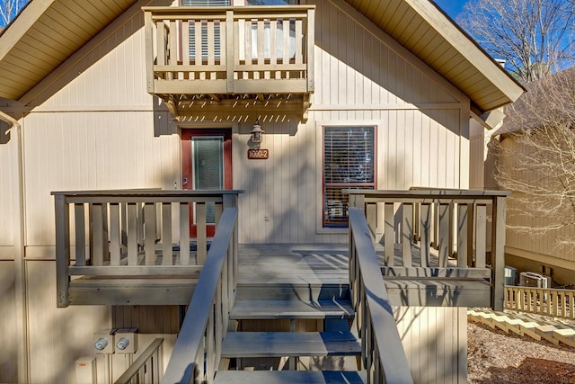 entrance to property featuring a wooden deck and a balcony